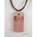 Shamballa bead necklace pendant pink on concrete pedestal decorated rectangle glittery pink and gold metal sheet