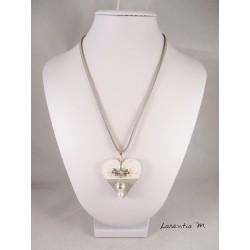 Collier pendentif avec perles cirées argent/blanche, suspendues à un noeud papillon, sur socle de béton coeur blanc pailleté