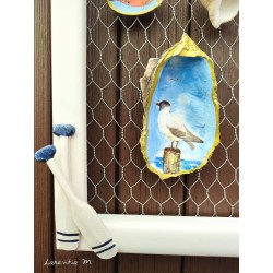 Painting of painted shells, coral, starfish, white wooden frame