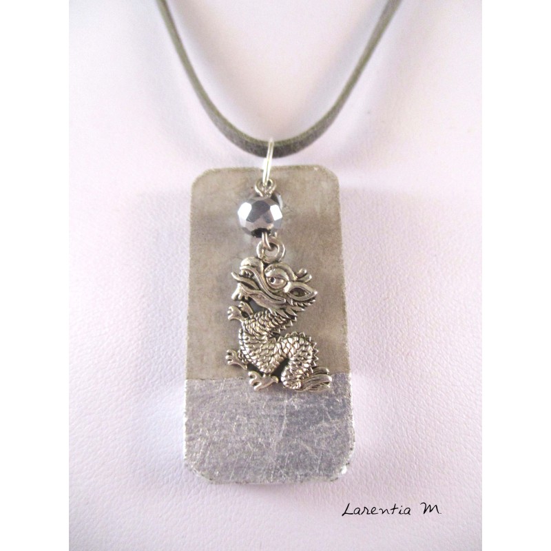 A pendant silver dragon hanging from a crystal pearl gray Bohemia. The cord is gray suede and measures about 40 cm.