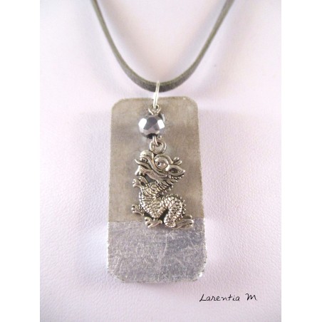 A pendant silver dragon hanging from a crystal pearl gray Bohemia. The cord is gray suede and measures about 40 cm.
