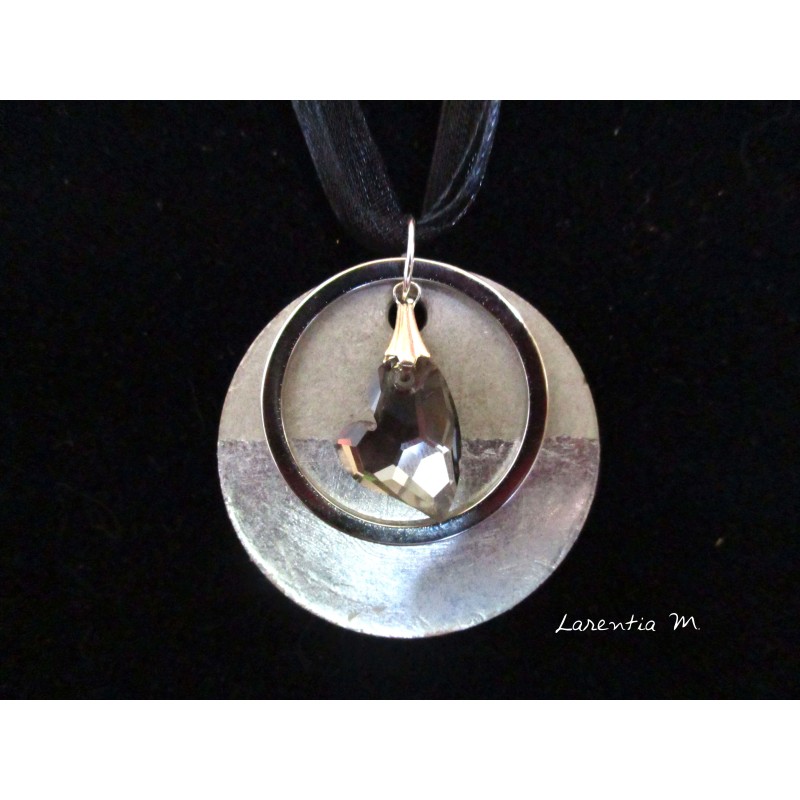Collier, pendentif "Coeur de cristal" gris avec anneau argenté sur socle de béton