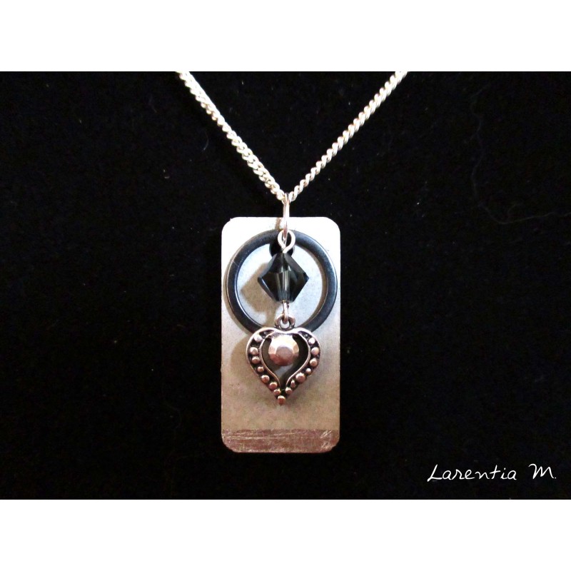 Collier pendentif avec perles cristal Swarovski noire, anneau et coeur argent sur socle de béton