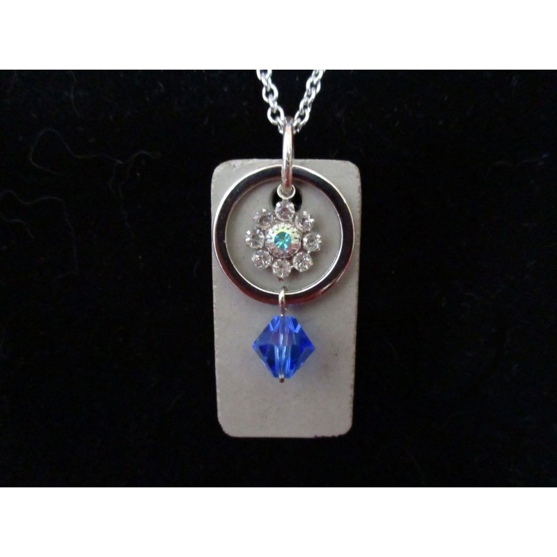 Necklace with Swarovski crystal ring and blue beads on concrete pad
