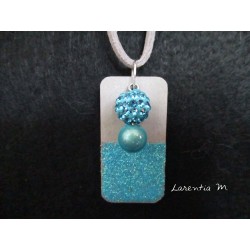 Collier pendentif perle Shamballa bleue et perle magique bleue sur socle de béton rectangle peint bleu avec paillettes
